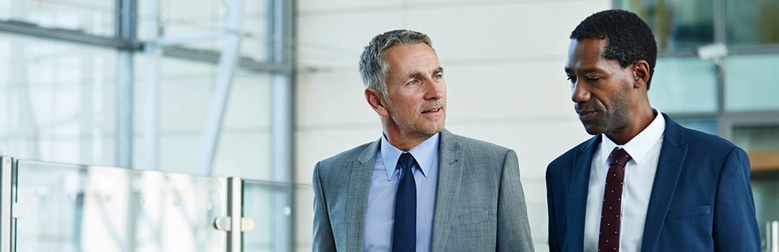 Two businesspeople having a conversation in a conference room.