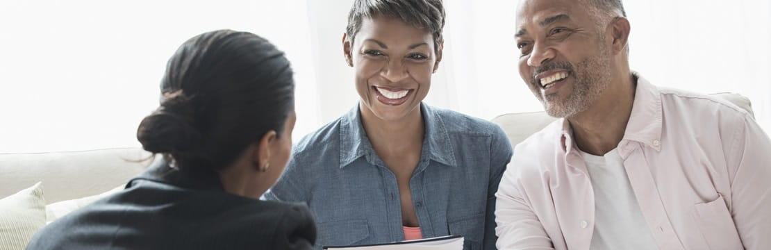 Mature Black couple talking to businesswoman